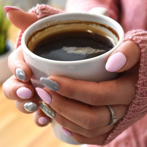manicured nails holding cup of coffee