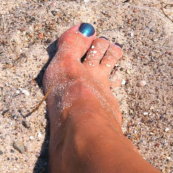 pedicured nails walking on sand